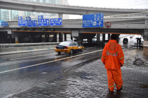 7月20日，一名北京排水集团工作人员在西直门桥附近监测积水情况。当日，北京排水集团应急抢险大队在暴雨中进行监测与排水工作。当日11时30分，北京市气象台发布暴雨橙色预警，目前城区及南部地区6小时累计降水量达70毫米左右，局地超过100毫米，预计至20日傍晚强降水持续。新华社记者 李鑫 摄